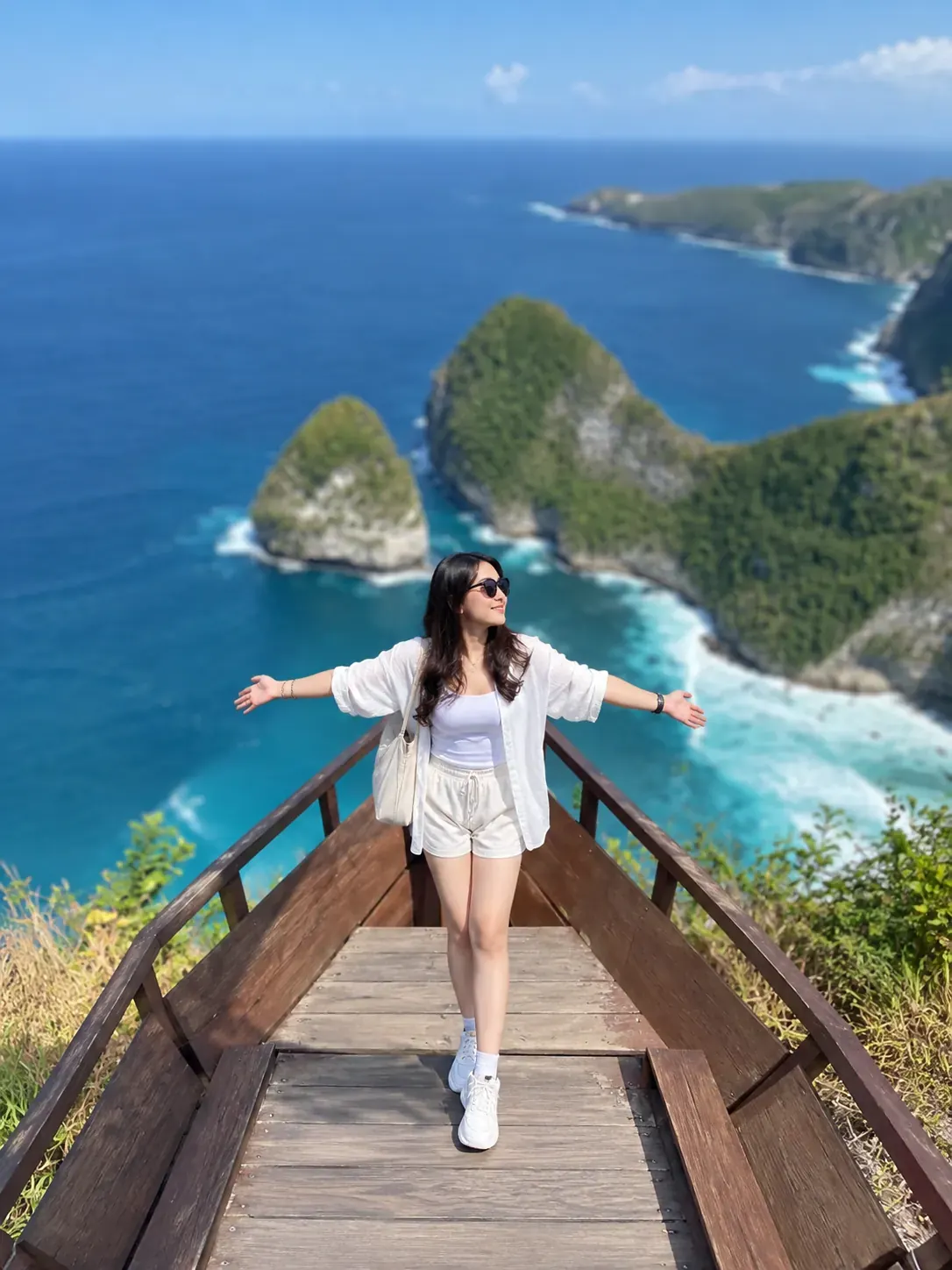 Visitor at a Kelingking viewpoint above the blue ocean